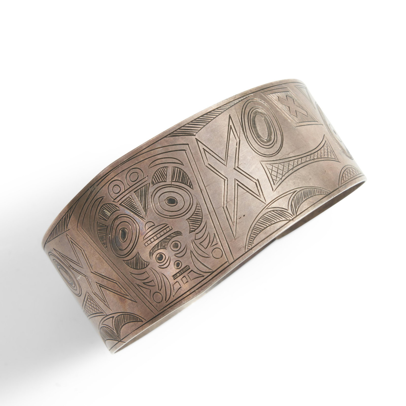 A large Northwest coast silver bracelet wd. 1 1/2, dia. 3 in.: A large Northwest coast silver bracelet The clasp bracelet decorated with engraved clan totem motifs. wd. 1 1/2, dia. 3 in.