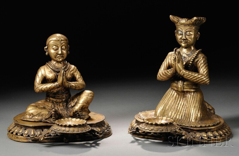 Two Nepalese Gilt-bronze Donor Figures, 18th century, i: Two Nepalese Gilt-bronze Donor Figures, 18th century, in meditation mudra, one is seated and one is kneeling, both on lotus thrones with attached offering dishes, ht. 9 5/8 and 11 3/4 in., respectivel