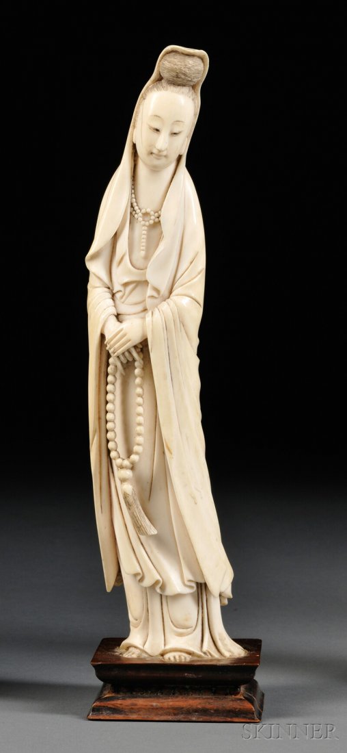 Ivory Carving, China, 19th century, standing figure of: Ivory Carving, China, 19th century, standing figure of Kuan Yin, hands folded on top of one another with a string of beads in her hands, glued to base, ht. 10 1/2 in.