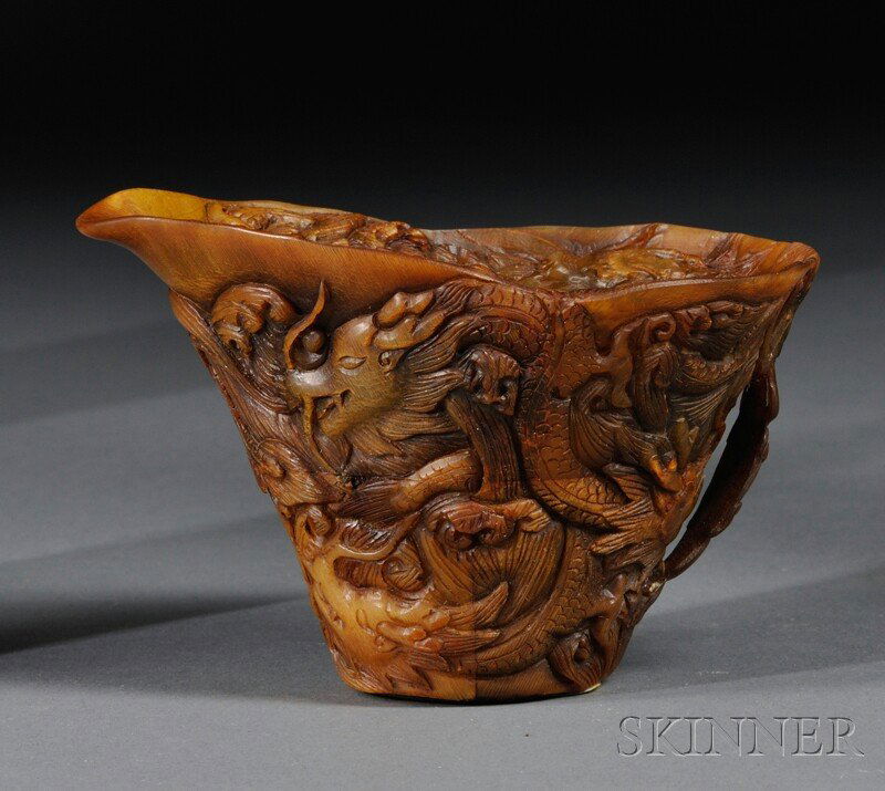 Horn Libation Cup, China, 19th/20th century, depicting: Horn Libation Cup, China, 19th/20th century, depicting scrolling dragons on the exterior and interior with a small, carved sphere in the center of the cup depicting a pearl, ht. 2 1/2, dia. 4 in.