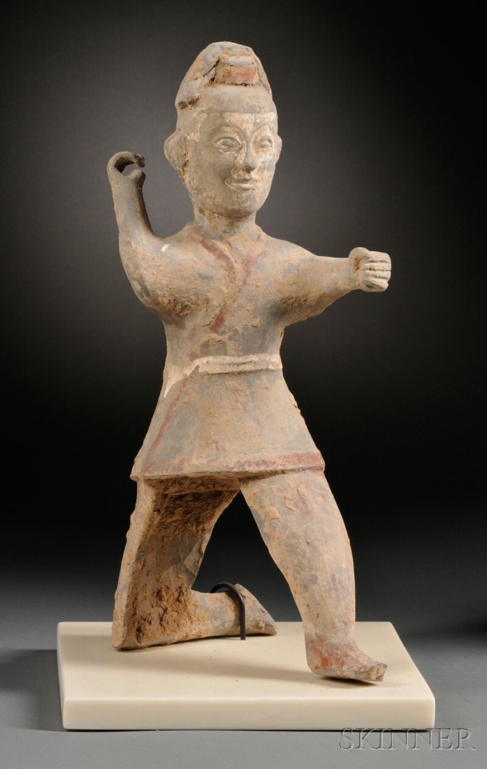 Pottery Figure of an Archer, China, Han dynasty (206 B.: Pottery Figure of an Archer, China, Han dynasty (206 B.C.-220 A.D.), kneeling on one leg with his right arm raised and wearing a short belted tunic, finely modeled face, traces of pigment and burial d
