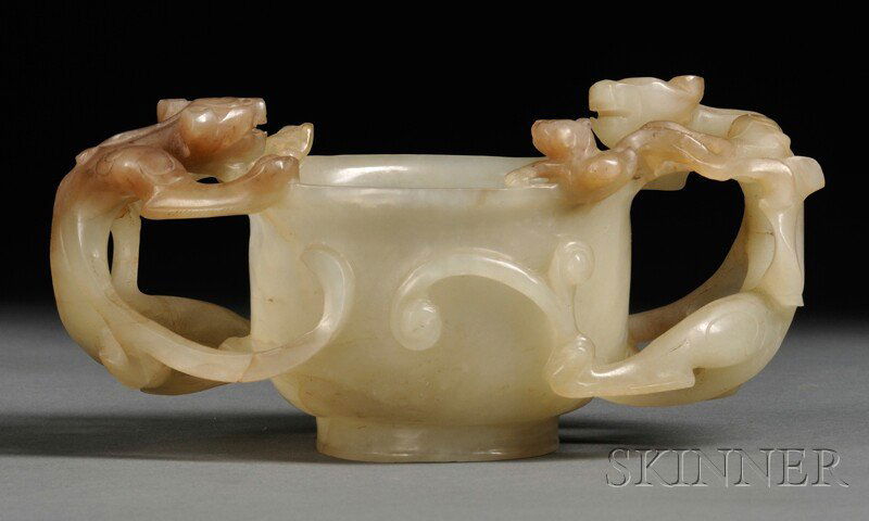 Jade Cup, China, Ming dynasty (1368-1644), with a pair: Jade Cup, China, Ming dynasty (1368-1644), with a pair of chilong dragon handles, supported on a short foot ring, stone of gray-celadon color with dark brown markings and inclusions, lg. 5 1/4 in.