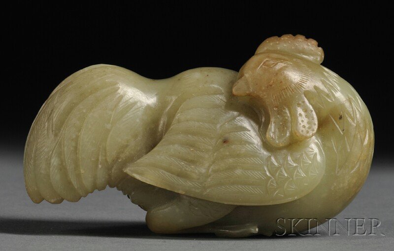 Jade Carving, China, depicting a recumbent bird with it: Jade Carving, China, depicting a recumbent bird with its head turned sharply to its right, the stone of yellowish-green color with russet markings, lg. 3 1/2 in.