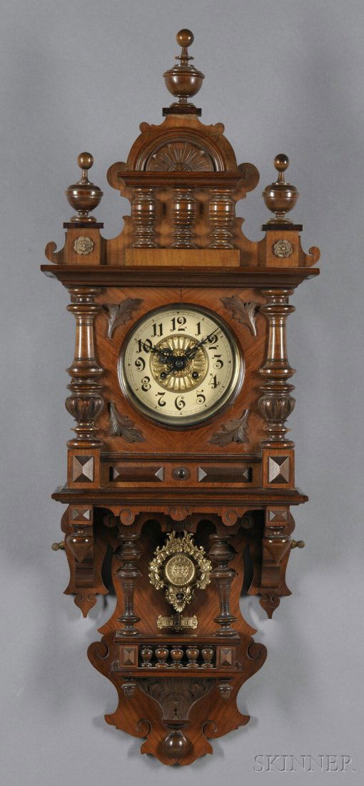 "Berliner" Walnut Wall Clock, Germany, c. 1900, ca: "Berliner" Walnut Wall Clock, Germany, c. 1900, carved and turned case with half columns flanking the Arabic numeral dial, lower pendulum section with free-standing columns, beat scale and carved pedi