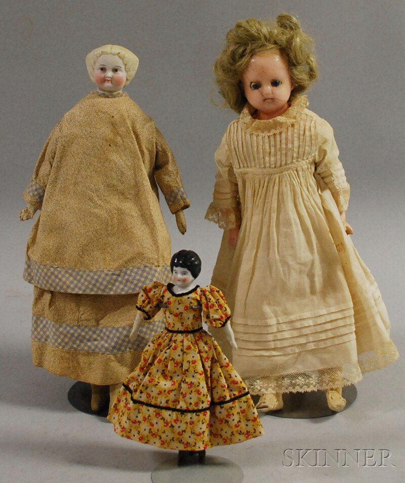 Three Dolls, late 19th and early 20th century, a wa: Three Dolls, late 19th and early 20th century, a wax girl with cloth body and composition limbs; a blonde parian with cloth body, kid arms, both ht. 14; and a small black-haired china doll marked 9 Ge