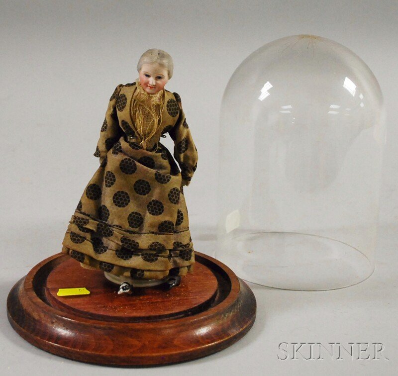 Gray-haired Dollhouse Doll in Dome, Germany, early: Gray-haired Dollhouse Doll in Dome, Germany, early 20th century, older woman with hair pulled back in bun, blue intaglio eyes, dimpled wrinkles, shoulder head, cloth body, bisque limbs, ht. 7 in.