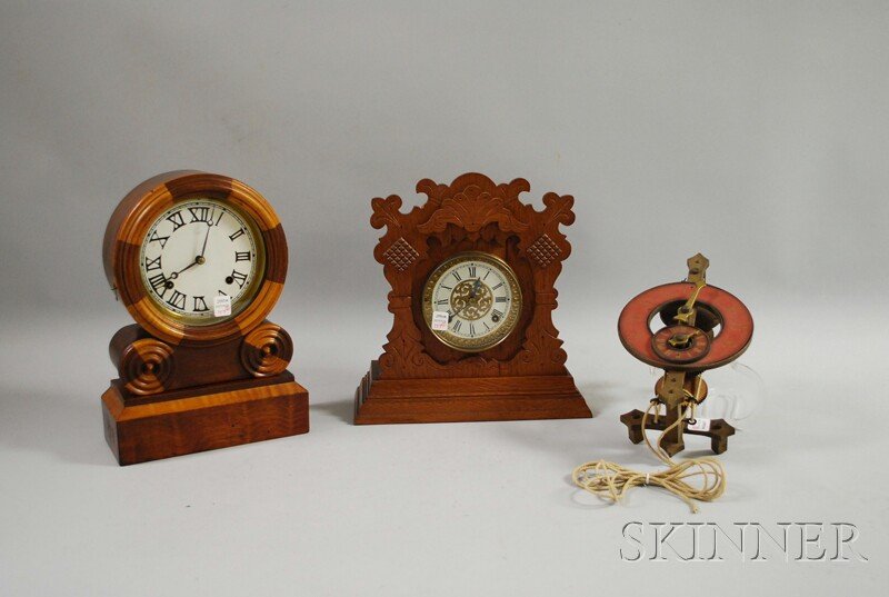 Two Mantel Clocks and a Swiss Wall Clock, an E. In: Two Mantel Clocks and a Swiss Wall Clock, an E. Ingraham "Grecian" shelf clock with paper Roman numeral dial, eight-day time and strike spring-powered movement; an oak cased Ansonia with pressed brass