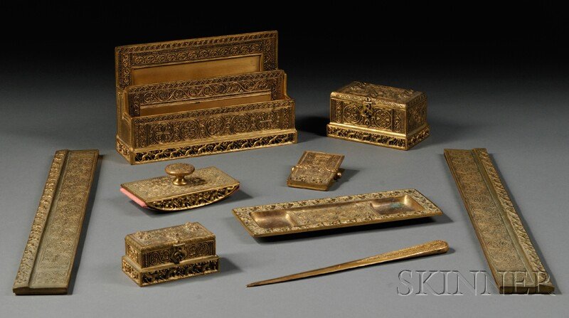 , Tiffany Studios Nine-piece Desk Set, Bronze dore: Tiffany Studios Nine-piece Desk Set Bronze dore Venetian pattern, New York, early 20th century Letter holder, no. 1644; two blotter ends, no. 1696; double inkwell, no. 1641; stamp box, no. 1645; hand 
