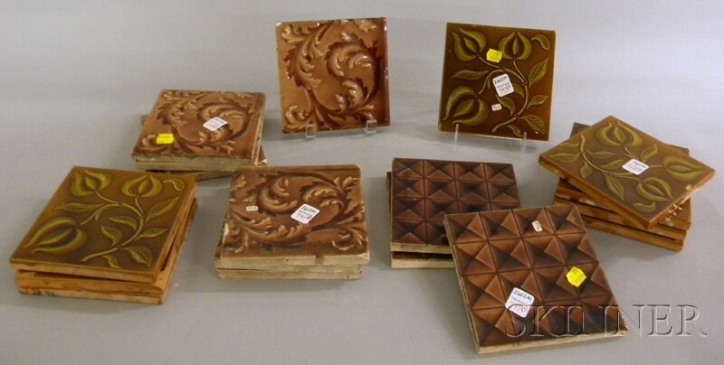 Eighteen Brown-glazed Relief-decorated Molded Art: Eighteen Brown-glazed Relief-decorated Molded Art Pottery Tiles, a set of eight Maw & Co. floral sprig pattern tiles, a set of seven Beaver Falls Art Tile Co. leaf scroll pattern, and a set of three g