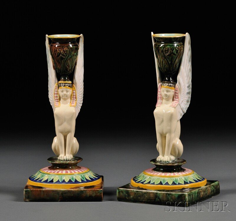 Pair of George Jones Majolica Sphinx Candlesticks,: Pair of George Jones Majolica Sphinx Candlesticks, England, late 19th century, modeled as a winged sphinx with the sconce as an urn on the top of her head, all on a square platform, pad mark to one, h