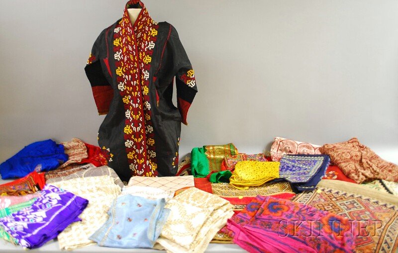 Group of Assorted Continental Textiles, including: Group of Assorted Continental Textiles, including a Turkish bagface, paisley shawl, Moroccan rug, South Asian robe, and various other fabrics, bedspreads, pillowcases, etc.