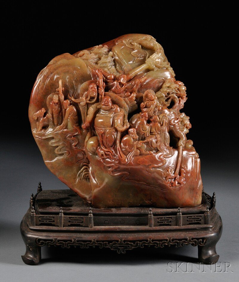 Soapstone Boulder on Wood Stand, China, 20th centu: Soapstone Boulder on Wood Stand, China, 20th century, carved on one side in high relief with Bodhisattvas engaging in various activities in a landscape scene, with a dragon flying above pavilions nest