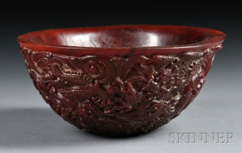 Horn Bowl, China, 20th century, the exterior carve: Horn Bowl, China, 20th century, the exterior carved with dragons chasing flaming pearls over a ground of rolling waves, four-character Qianlong mark incised on base, dia. 4 1/2 in.