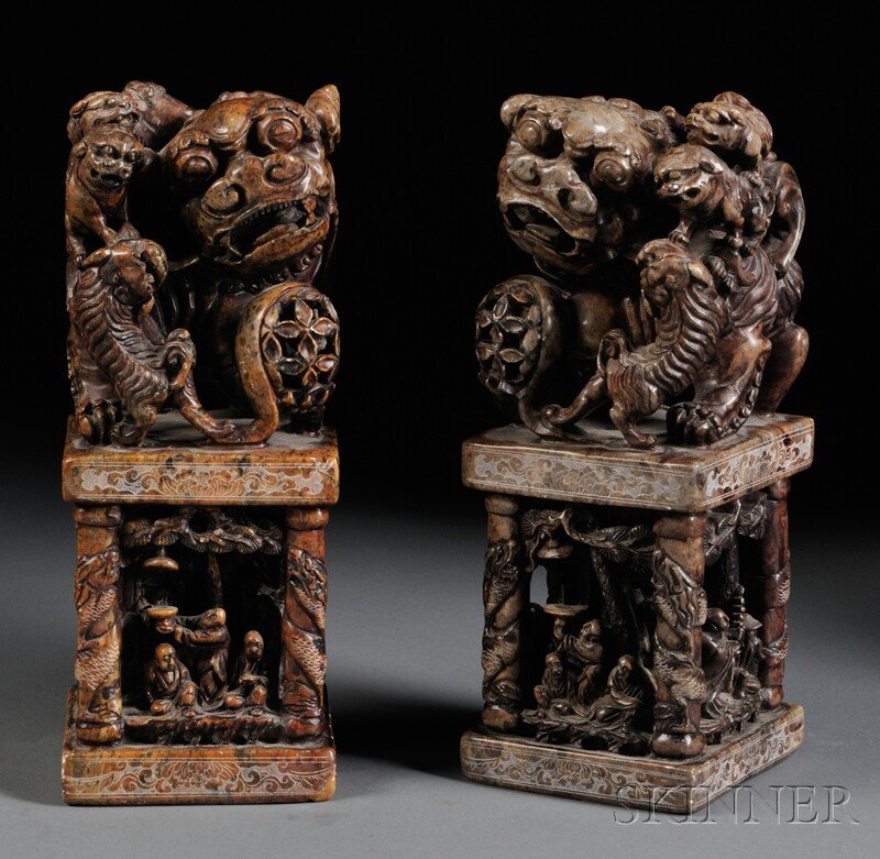 Pair of Hardstone Seals, China, 20th century, rect: Pair of Hardstone Seals, China, 20th century, rectangular, the four sides framed by dragon columns and carved with Buddhist figures beneath pine trees in relief, surmounted by a foo lion with four pla