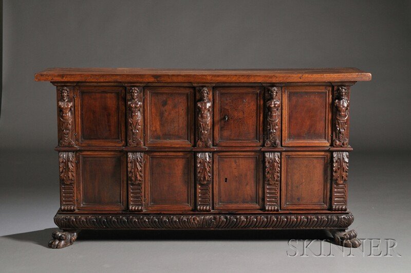 Carved Fruitwood Credenza, northern Italy, with tw: Carved Fruitwood Credenza, northern Italy, with two rows of four doors separated by carved figural decoration to upper section and acanthus scrolls to the lower, with two large lion's paw front feet, 