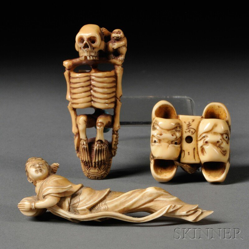 Three Ivory Netsukes, Japan, a group of seven Noh m: Three Ivory Netsukes, Japan, a group of seven Noh masks, signed, lg. 1 3/8, a reclined goddess holding a barrel, lg. 3 1/4, and a skeleton resting its feet on top of a turtle shell between its hands,