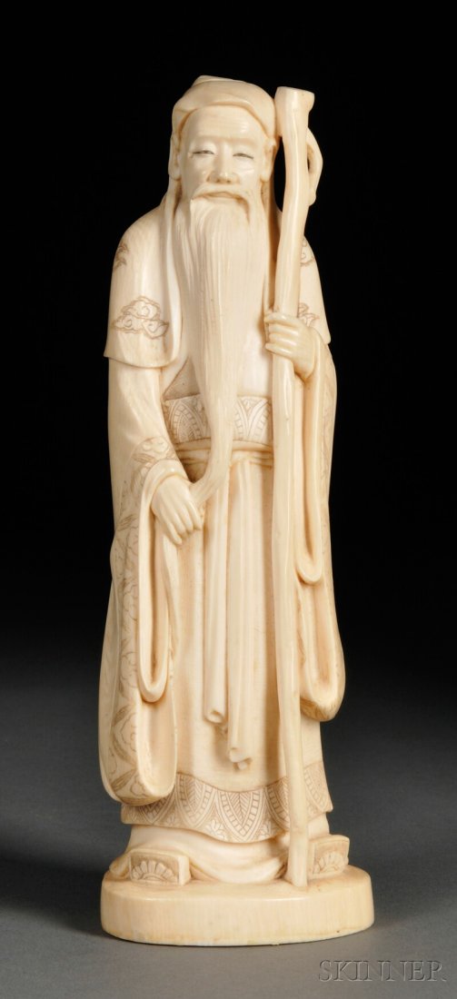 Ivory Carving, Japan, depicting an old man as stand: Ivory Carving, Japan, depicting an old man as standing and wearing a cloak incised with cloud design, holding a staff in one hand and stroking his long beard with the other, signed on base, ht. 6 7/8 