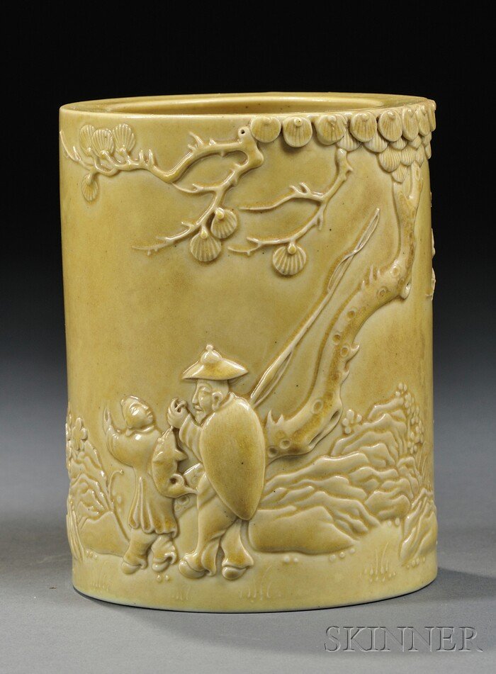 Yellow Brush Pot, China, cylindrical, the sides mo: Yellow Brush Pot, China, cylindrical, the sides molded with a recluse and his attendant under an overarching pine in a rustic landscape, covered by an egg-yolk yellow glaze, "Wang Bingrong" mark to th