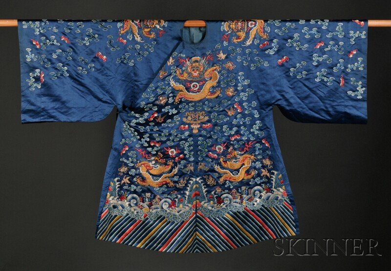 Dragon Robe, China, embroidered on blue silk with: Dragon Robe, China, embroidered on blue silk with eight dragons amidst clouds, bats, and other auspicious emblems, all above a lishui border and rolling waves.