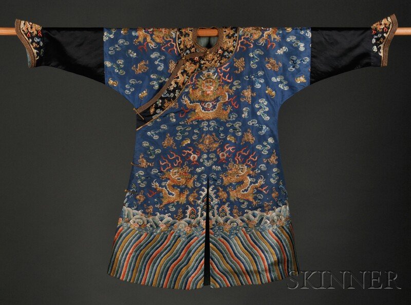 Dragon Robe, China, embroidered on blue silk with: Dragon Robe, China, embroidered on blue silk with eight gold-couched dragons amidst clouds, bats, and Buddhist emblems, all above a lishui border with rolling waves.