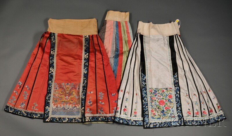 Three Embroidered Skirts, China, one of red silk w: Three Embroidered Skirts, China, one of red silk with gold-couched dragons amidst bats and Buddhist emblems; one of white silk embroidered with garden scenes depicting peonies, butterflies, and rocks;