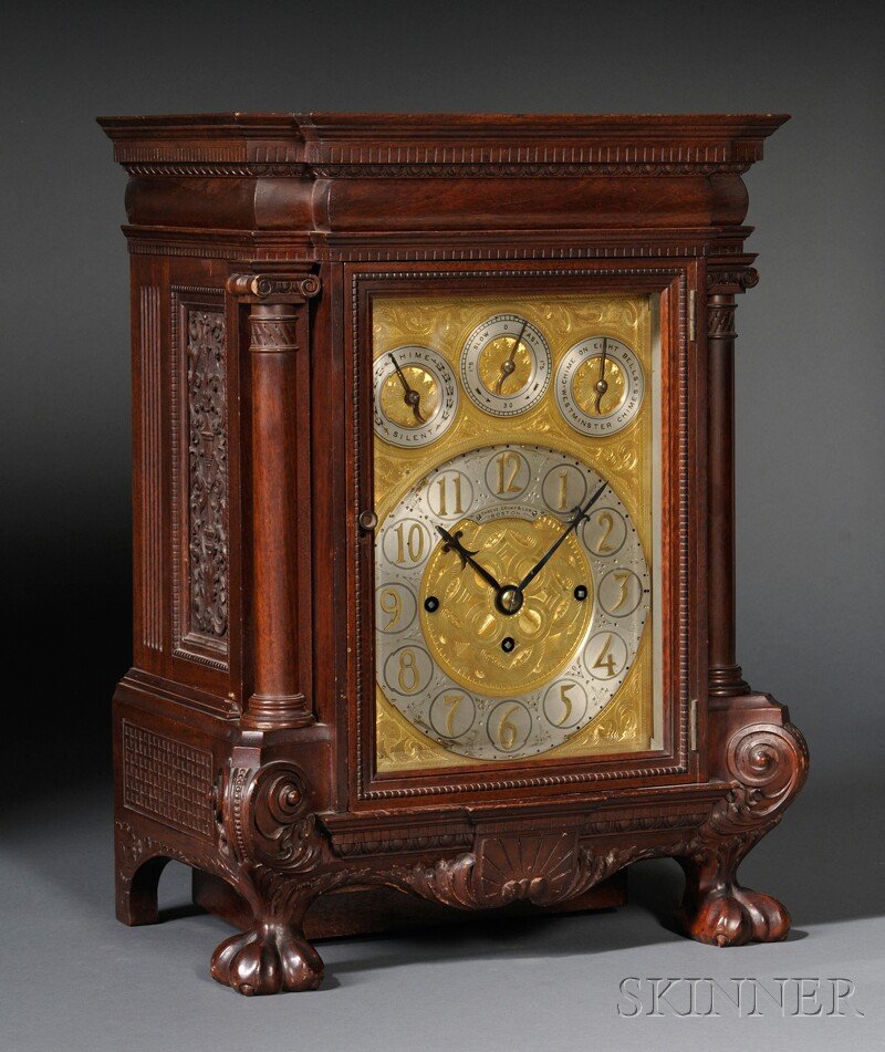 Shreve, Crump & Low Mahogany Table Clock, attribut: Shreve, Crump & Low Mahogany Table Clock, attributed to Elliott, London, c. 1900, the case with three-quarter columns flanking the rectangular beveled glass door, dentil-carved frieze, fully carved si