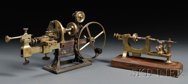 Two Brass and Steel Watchmaker's Mandrels, Switzer: Two Brass and Steel Watchmaker's Mandrels, Switzerland, 19th century, one marked J & T Jones, Prescot, with tool rest and a single pin tailstock, mounted on a wood stand, lg. 12 in.; the other with an