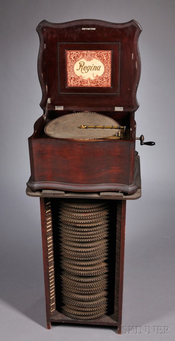 Regina 15 1/2-inch Disc Musical Box, no. 53789, wi: Regina 15 1/2-inch Disc Musical Box, no. 53789, with double combs and star-wheel assembly, long bed plate, brass sugar-twist pressure bar, print with nine cherubs on underside of lid, celluloid plaque
