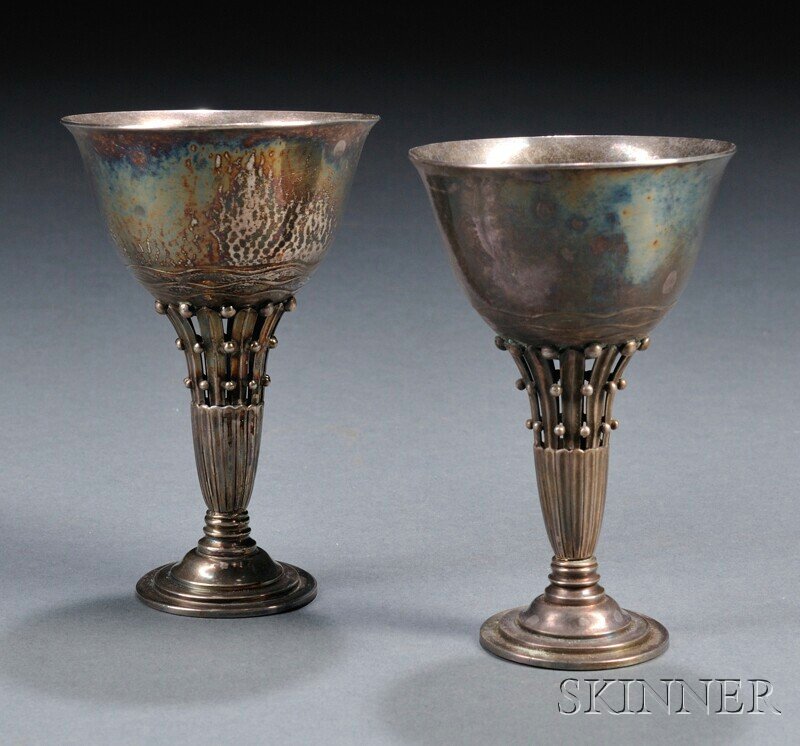 , Two Pieces of Georg Jensen Stemware, Sterling sil: Two Pieces of Georg Jensen Stemware Sterling silver Denmark, c. 1925-32 Goblet with wave decoration at base, leaf and bead openwork stem joined to stepped circular base marked Dessin, Georg Jensen in 