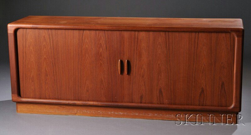 , Danish Modern Sideboard, Teak, teak veneer, The: Danish Modern Sideboard Teak, teak veneer Dyrlund, Denmark The curved edge form with two tamboured sliding doors containing two storage consoles with two adjustable shelves flanking five small interio