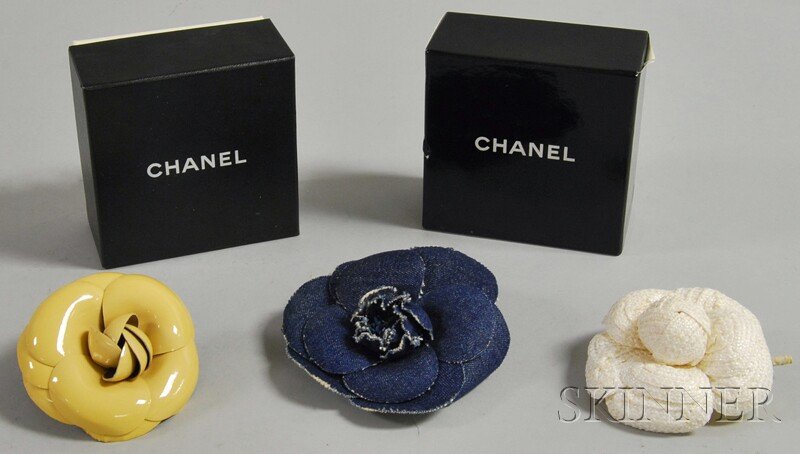 Three Chanel Flower Pins/Brooches, in denim, beige: Three Chanel Flower Pins/Brooches, in denim, beige patent leather, and white straw, two with Chanel boxes, approx. dia. 3 to 4 1/2 in.