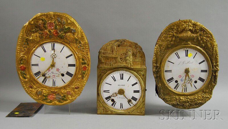 Three Morbier Wall Clocks, each having porcelain: Three Morbier Wall Clocks, each having porcelain dials with Roman numerals, pressed brass dial surround with flowers and leafage, (missing weights, pendulums).