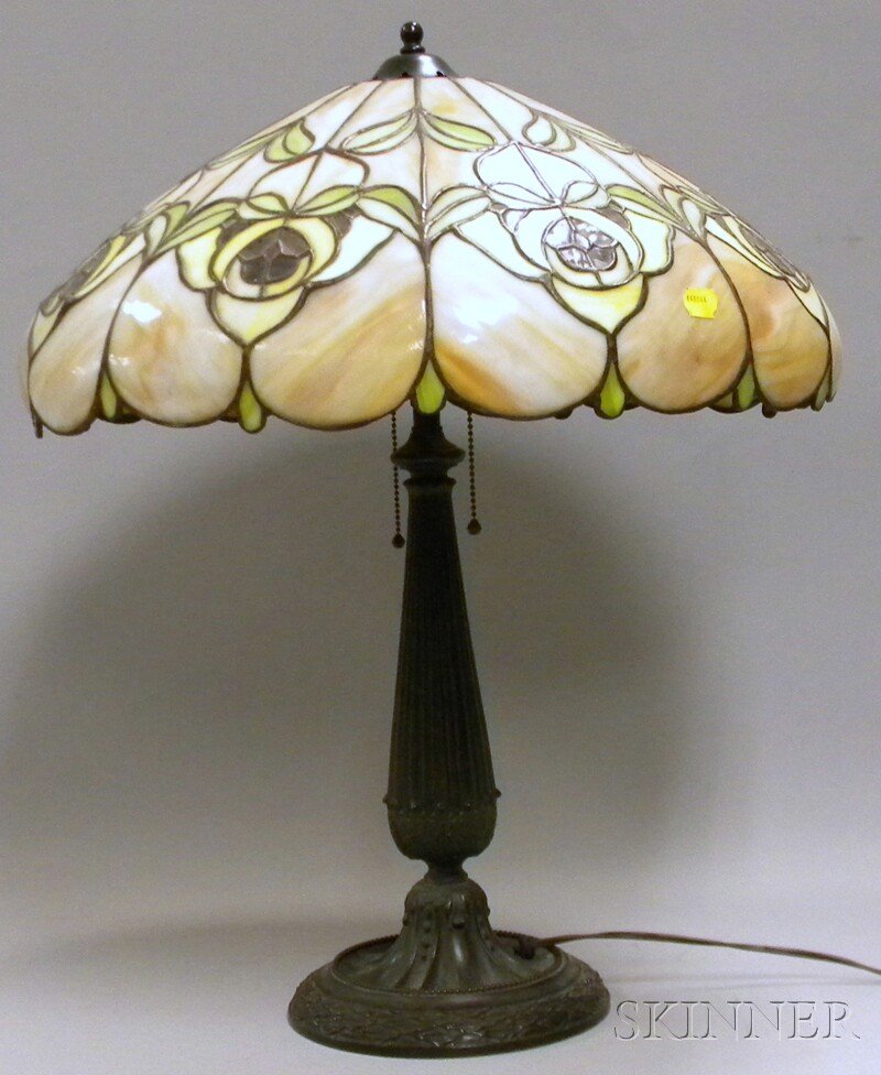 Leaded Slag Glass Floral Pattern Lamp Shade with: Leaded Slag Glass Floral Pattern Lamp Shade with a Patinated Cast Metal Table Lamp Base, the base with two original sockets and belted ball chain pulls, shade dia. 19 1/4, base ht. 24 1/4 in.