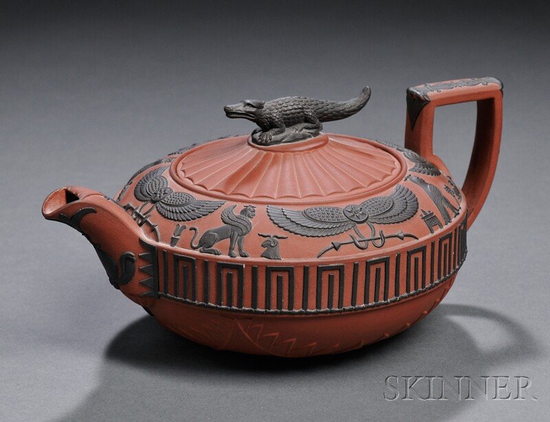 Wedgwood Rosso Antico Egyptian Teapot and Cover, E: Wedgwood Rosso Antico Egyptian Teapot and Cover, England, early 19th century, applied black basalt relief with a crocodile finial and bands of hieroglyphs and meander above stylized motif, impressed m