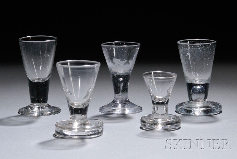 Five Pieces of Soda Glass, 18th century, three fir: Five Pieces of Soda Glass, 18th century, three firing glasses: two with trumpet bowls and short plain stems on thick feet, ht. 2 5/8 and 3 1/2, and one with funnel bowl and short teared stem on thick 
