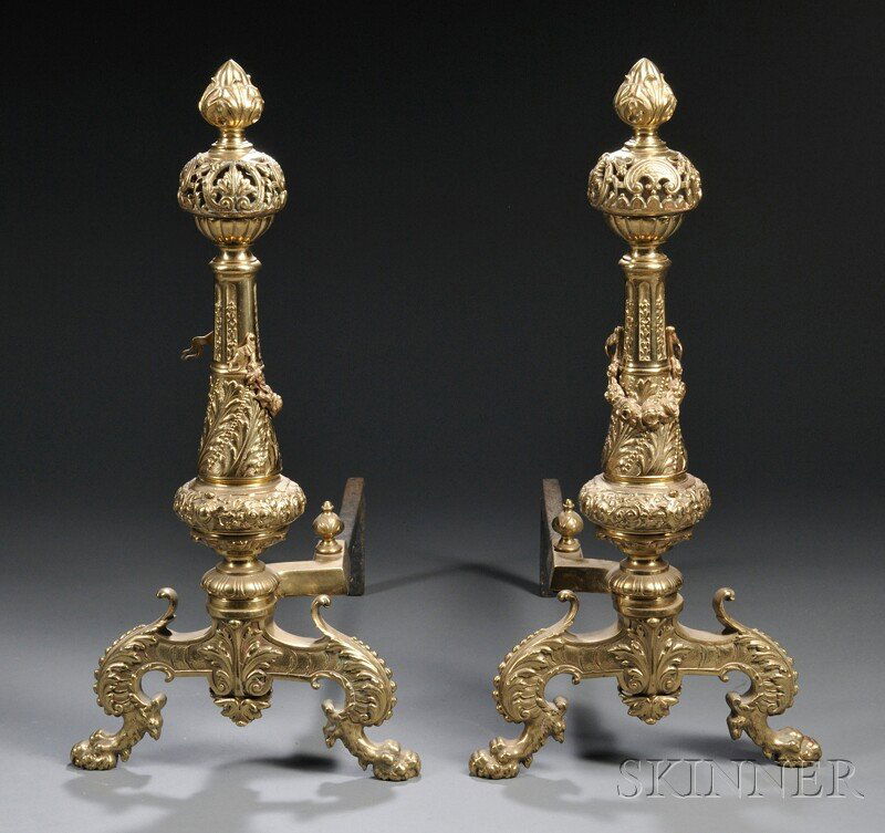 Pair of Brass Andirons, of typical form, cast with: Pair of Brass Andirons, of typical form, cast with a foliate finial above a pierced sphere raised on a tapered stem decorated with foliate and strapwork registers terminating splayed lion paw feet, ht