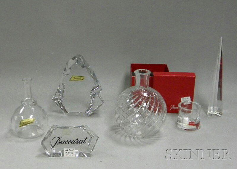 Five Baccarat Colorless Crystal Table Articles and: Five Baccarat Colorless Crystal Table Articles and Retail Display Sign, a "Tranquility" votive, triangular obelisk, bottle-form vase, a sculpture, and a "Boule" vase, table items with boxes, etched st
