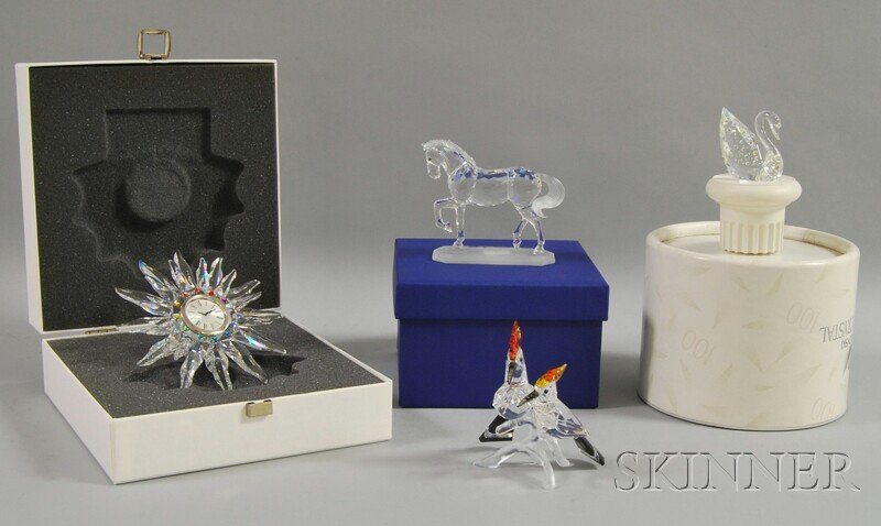 Four Swarovski Crystal Figural Items, a swan with: Four Swarovski Crystal Figural Items, a swan with pedestal, a bird figural group, a "Solaris" table clock, and an Arabian stallion, with boxes.
