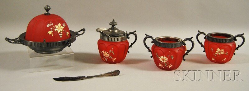 Four-piece Floral-decorated Metal-mounted Red Sati: Four-piece Floral-decorated Metal-mounted Red Satin Glass Table Set, creamer, two-handled open sugar, spooner, and covered butter dish, with silver-plated butter knife, ht. to 5 1/4 in.