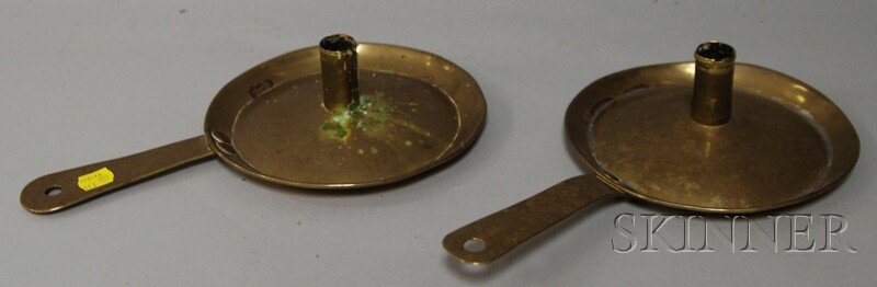 Two Brass Chambersticks, Holland or England, c. 18: Two Brass Chambersticks, Holland or England, c. 1800, with round, dished bases and pierced handles, (dents to rims, one with solder reinforcement), ht. 2 1/2, lg. 11 5/8 in.