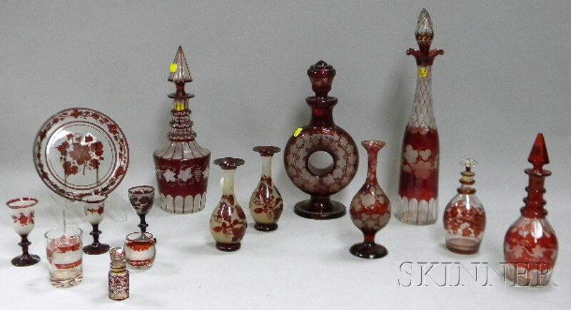 Fifteen Bohemian Etched Ruby Flash Art Glass Table: Fifteen Bohemian Etched Ruby Flash Art Glass Table Items, five decanters, a perfume bottle, a tray, a pair of vases, three cordials, a vase, and two souvenir glasses.