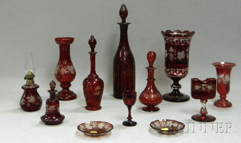 Twelve Pieces of Bohemian Etched Ruby Flash Art Gl: Twelve Pieces of Bohemian Etched Ruby Flash Art Glass, a pair of small dishes, four decanters and scent bottles, a cordial, a garniture vase, a playing card stand, a small oil lamp, and two vases.