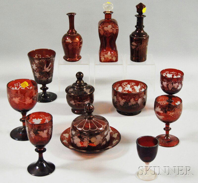 Twelve Bohemian Etched Ruby Flash Art Glass Table: Twelve Bohemian Etched Ruby Flash Art Glass Table Items, a finger bowl, six goblets and wines, two decanters, a covered jar, a vase, and a butter dish with cover.