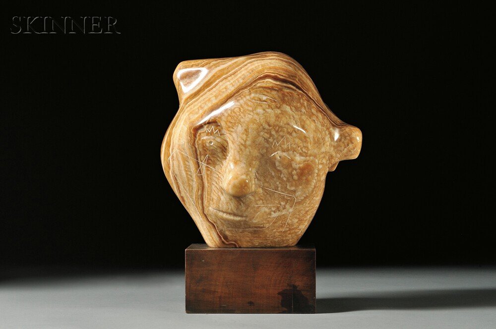 Armando Amaya (Mexican, b. 1935), Payaso, 1969, Si: Armando Amaya (Mexican, b. 1935) Payaso, 1969 Signed and dated "Amaya 69" on the reverse. Carved brown onyx, approximately 10 1/2 x 10 x 8 in. (26.7 x 25.4 x 20.3 cm), mounted to a wooden plin