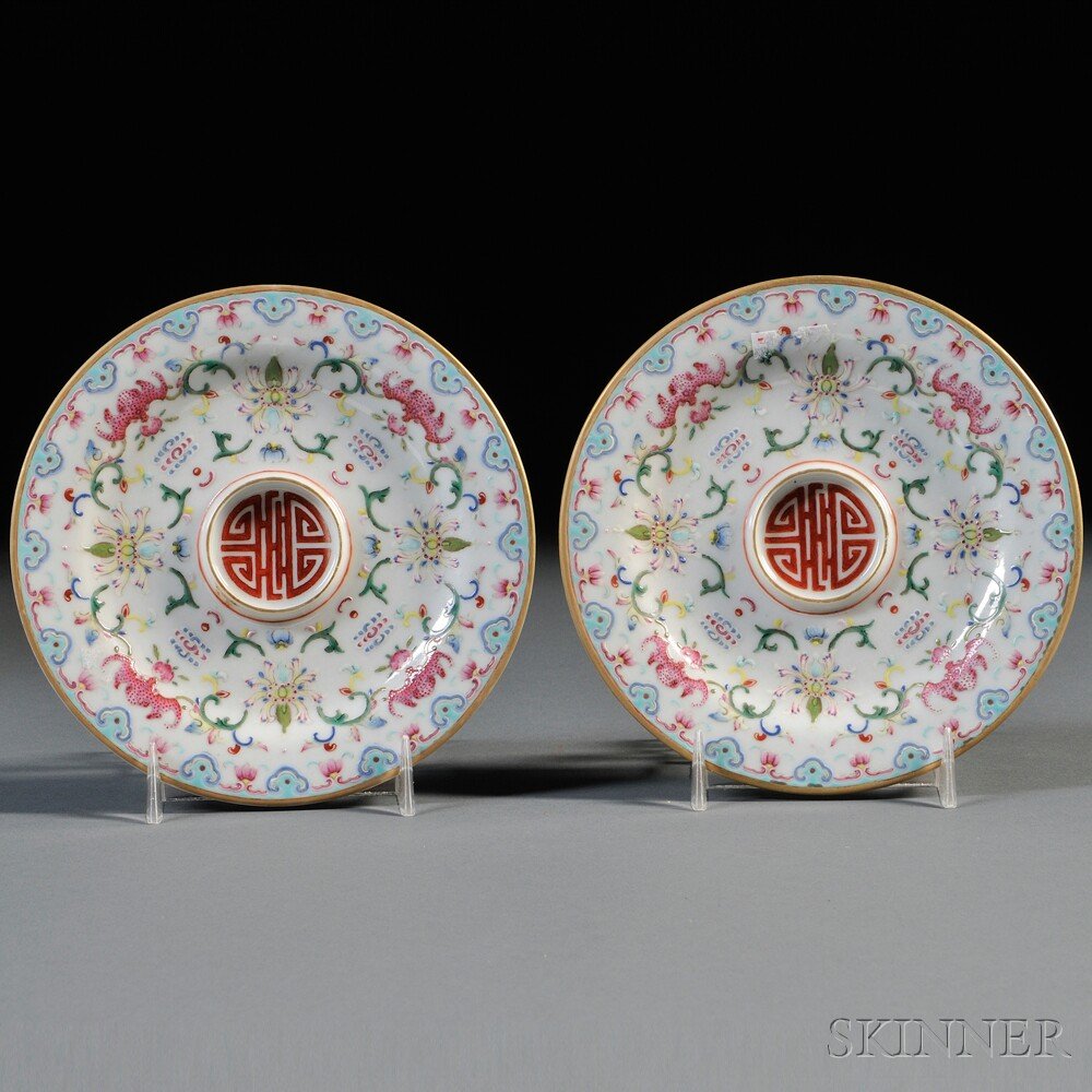 Pair of Small Famille Rose Saucers, China, 20th cen: Pair of Small Famille Rose Saucers, China, 20th century, decorated with red bats, peonies, and scrolls on white background, ruyi patterns interspersed with flowers along the gilt rim, exterior decorat
