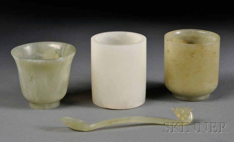 Four Stone Carvings, China, 20th century, one cup: Four Stone Carvings, China, 20th century, one cup with flared mouth, stone of pale green color, lg. 2; one cylindrical cup, white stone, lg. 2 1/4; one cylindrical cup raised on a short foot, lg. 2; o