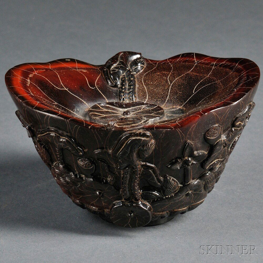 Carved Horn Cup, China, 20th century, formed as a: Carved Horn Cup, China, 20th century, formed as a lotus, the exterior carved with lotus flowers, pods, and leaves surrounding a bird and a fish, the base depicting waves, rising from the base on eithe