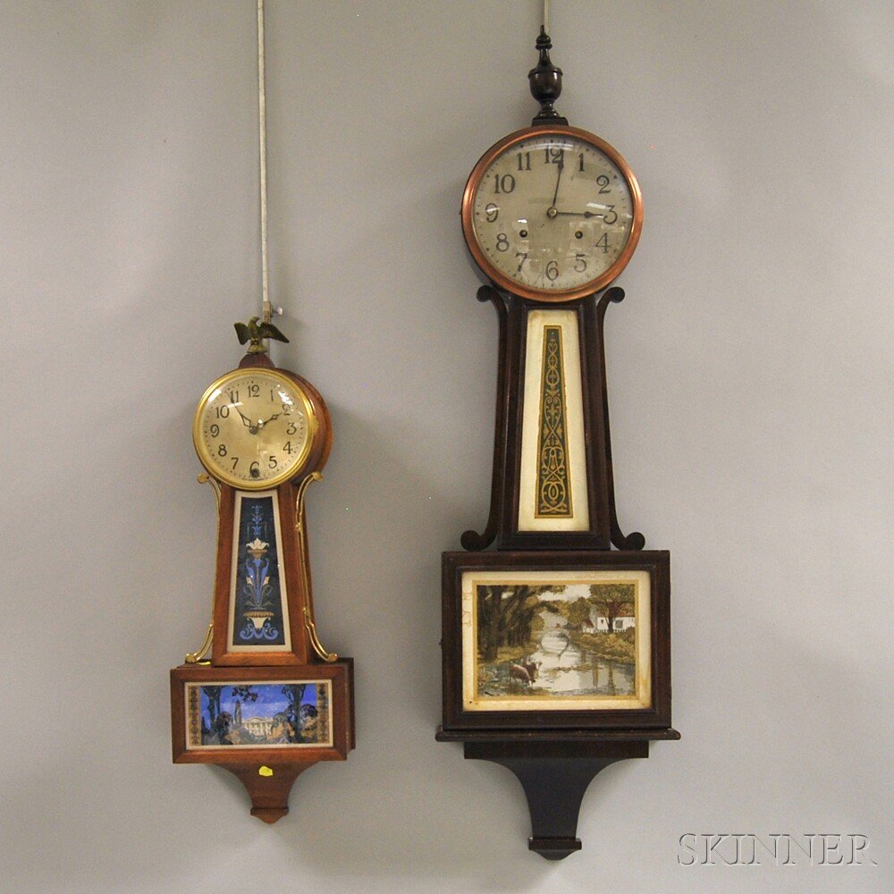 Two New Haven Banjo Clocks, both with mahogany cases, t: Two New Haven Banjo Clocks, both with mahogany cases, transfer-decorated tablets, and eight-day time and strike movements, one with 8-in. Arabic numeral silvered dial, the other a 5-in. Arabic numeral