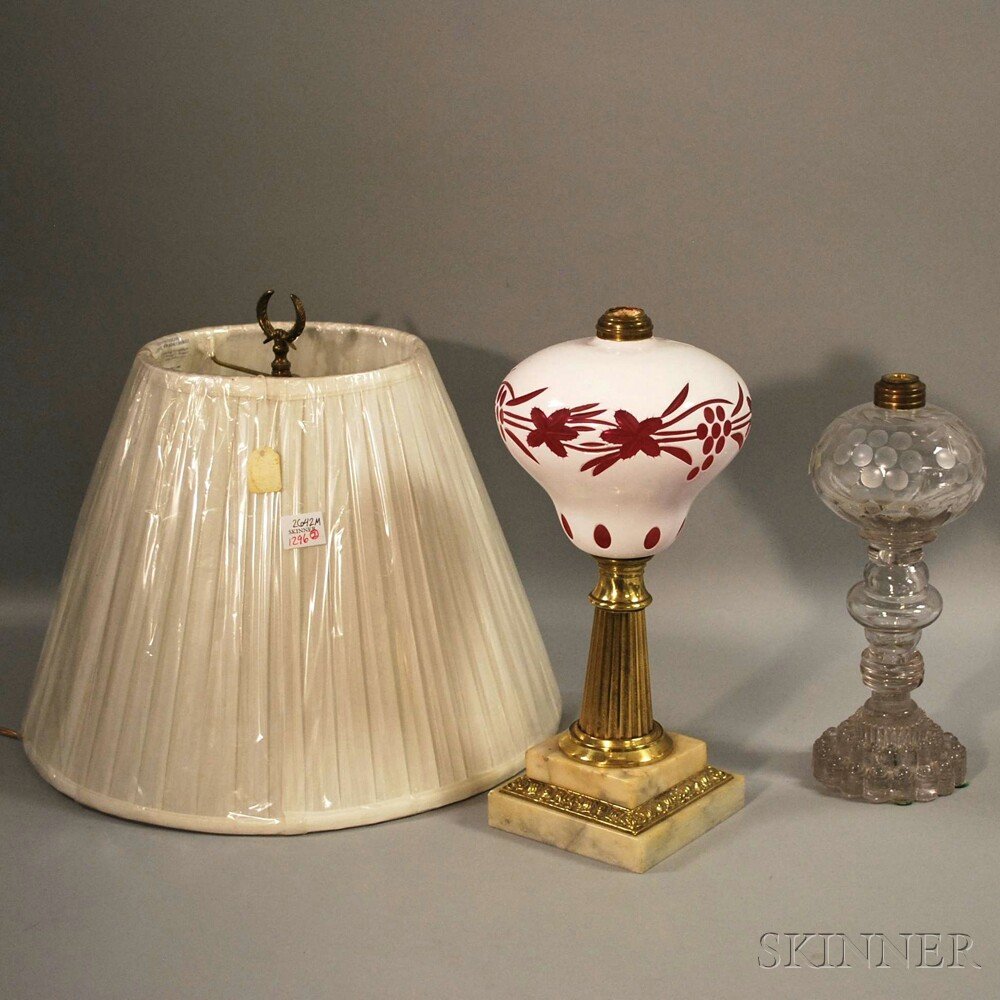 Early Etched Colorless Blown Molded and Pressed Glass O: Early Etched Colorless Blown Molded and Pressed Glass Oil Lamp and a Cased White-cut-to-ruby Glass and Gilt-brass Oil Lamp with Marble Base.