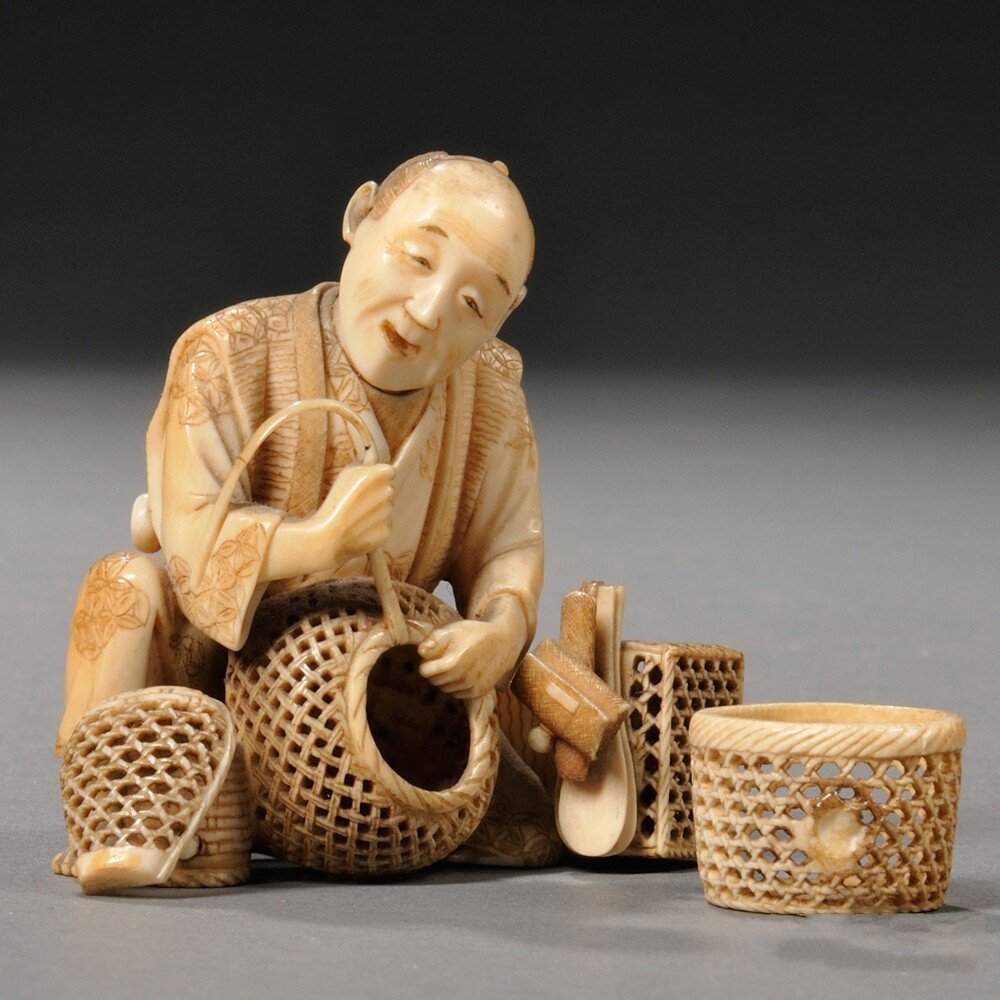 Ivory Okimono of a Basket Weaver, Japan, 19th/20th: Ivory Okimono of a Basket Weaver, Japan, 19th/20th century, working on a basket while sitting on one leg, signed in a red cartouche on base, ht. 2 1/2 in.